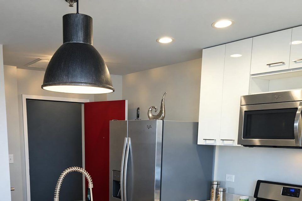 Pendant light and recessed ceiling lights in a kitchen.