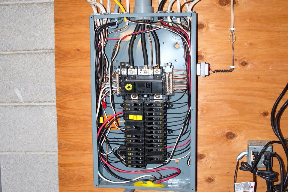 Open electrical panel in a utility room.